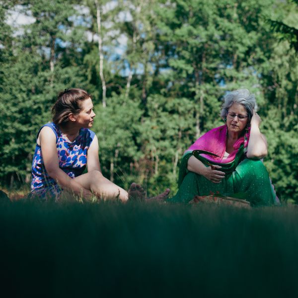 zwei Frauen träumen gemeinsam auf einer grünen Wiese